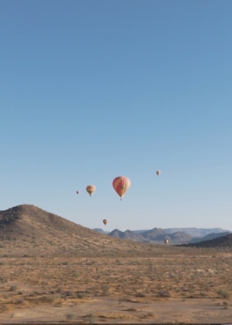 Hot air balloons float above foothills on a clear day, Scottsdale, Arizona